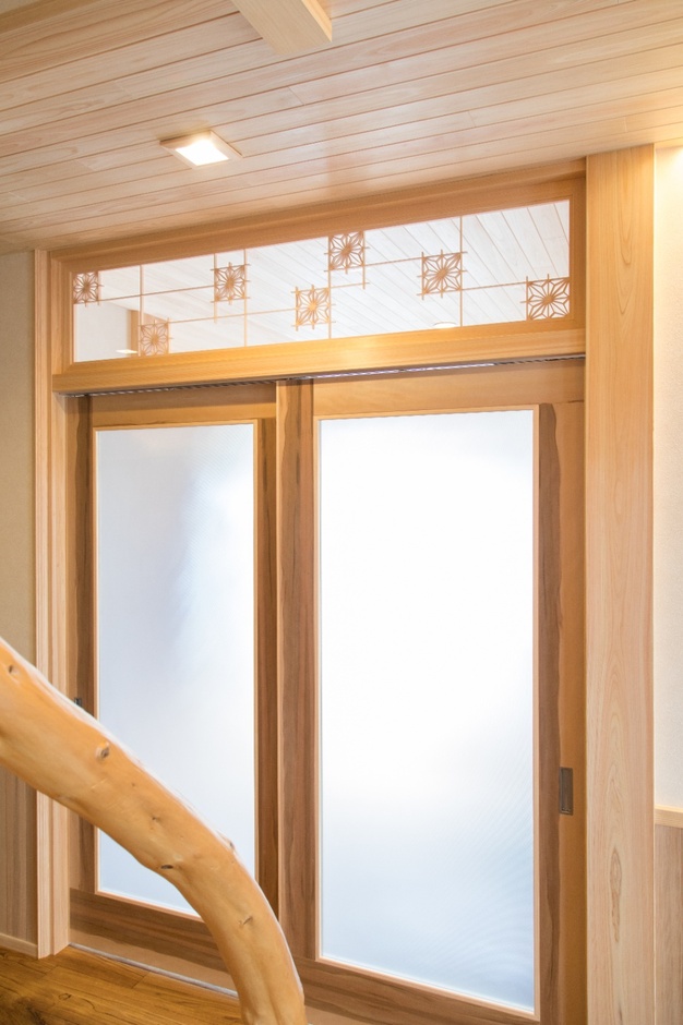 欄間に施された格子が優雅な印象を与え、廊下に光が柔らかく差し込む空間となっている。