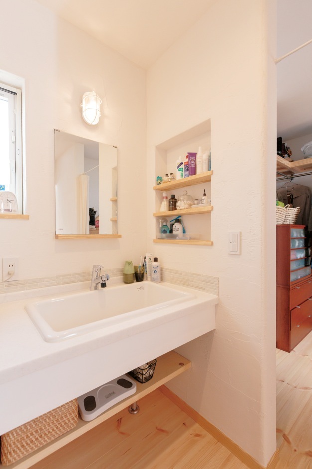 深いシンクはおしゃれ着洗いに便利。すぐ隣に鏡台とクローゼットを配置し、2階に上がる頻度も減った