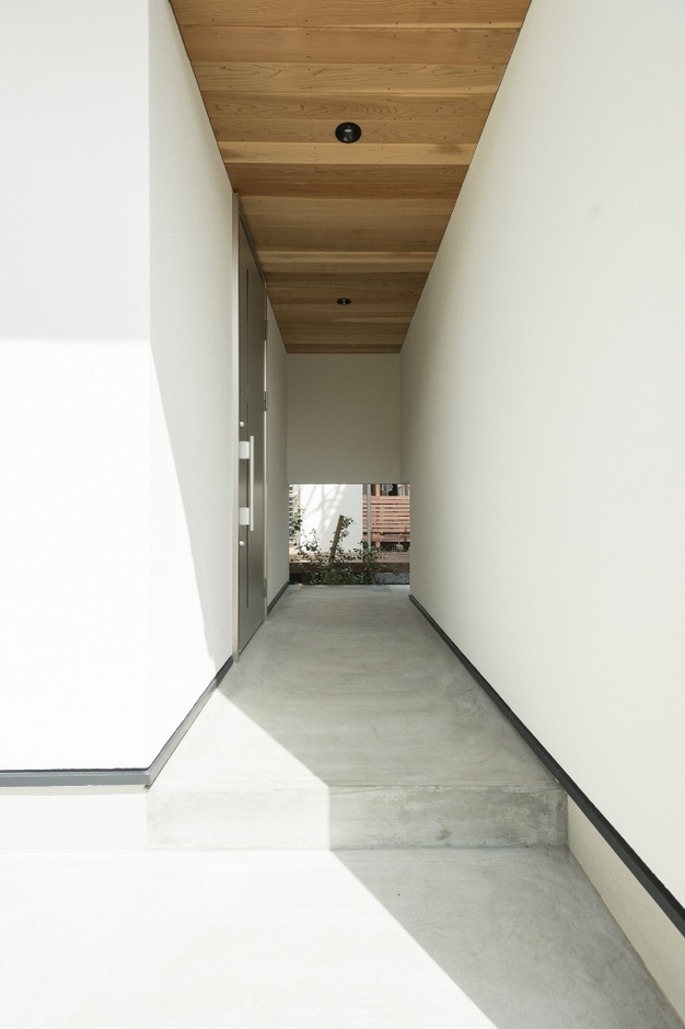 軒天井の板張りが美しい玄関アプローチ。向こう側へ通り抜けられる