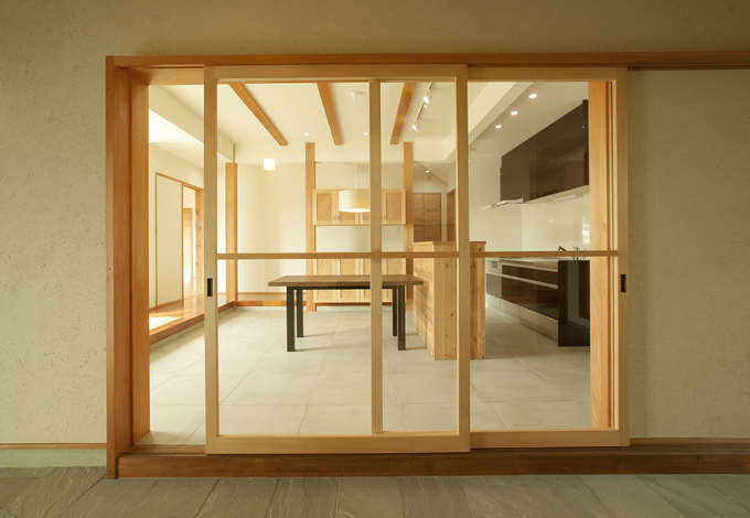 キッチンは玄関土間からつながり、大きなアクリルの建具を使用。夏場はフルオープンにできるため土間との一体の使い方ができる