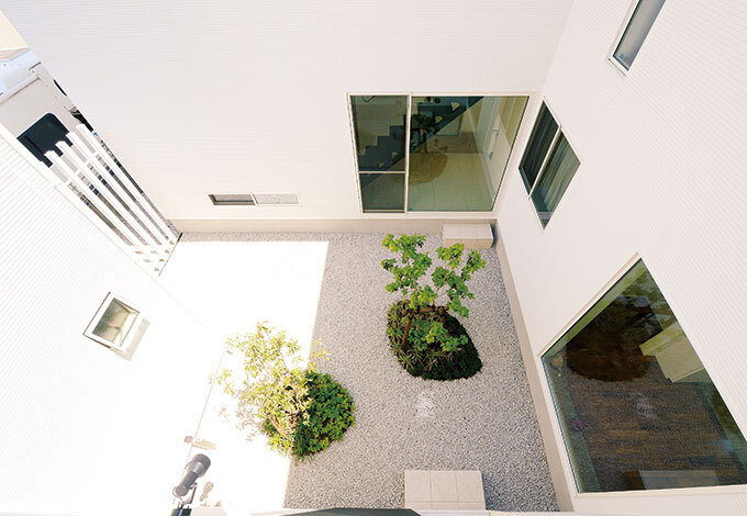 2階ダイニングの窓から中庭を見下ろす。大通りからは視線が遮られているので、光と風を浴びながらプライベートなリゾート感を満喫できる