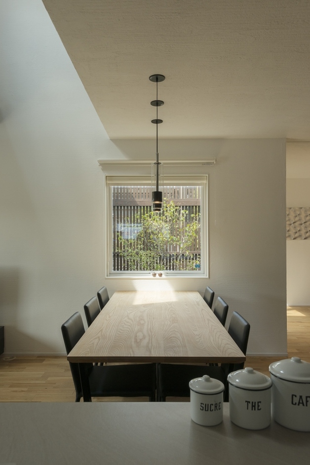 キッチンとダイニングの正面に四角の窓があり、まるで絵画のように空や緑が映りこむ