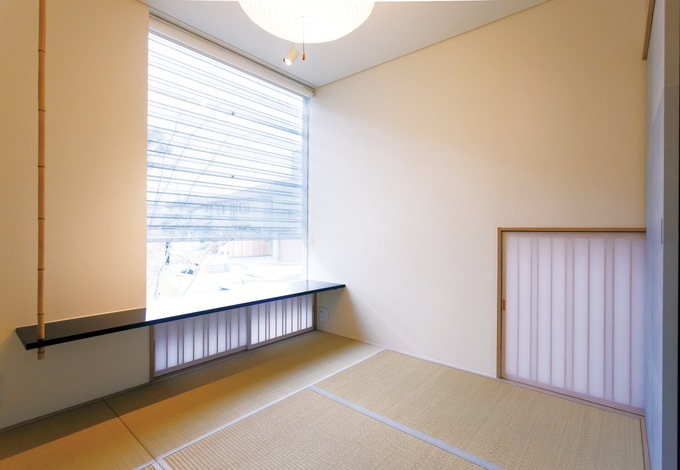 東京に住む長女家族が泊まりに来た時に使う和室。大きなFIX窓を設けて視線を遠くへ運んだり、畳の縁を細くして広く見せたり、アクセントに白竹を採用するなど、建築家の細やかな感性が宿る
