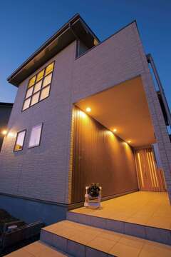 屋根付きの長いポーチは雨に濡れないので便利。玄関までの距離がこれだけあると、仕事モードから家庭モードへと気持ちのリセットも容易にできそう【住宅工房 アリアンス】