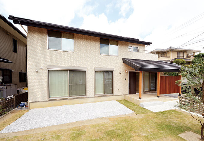 太陽光発電を搭載するため屋根の形状も考慮。落ち着いた雰囲気の外観にタイル素材を使うことで上質感が増している。庭の一部に菜園コーナーがつくられた