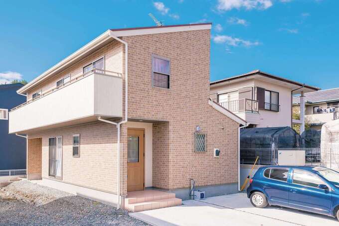 かわいい洋風の外観。汚れが目立つ白を避けてレンガ調にした外壁は、標準仕様の中から選べた。屋根は赤、バルコニーは白、壁は茶色とティラミスのような色合いが夫婦のお気に入り