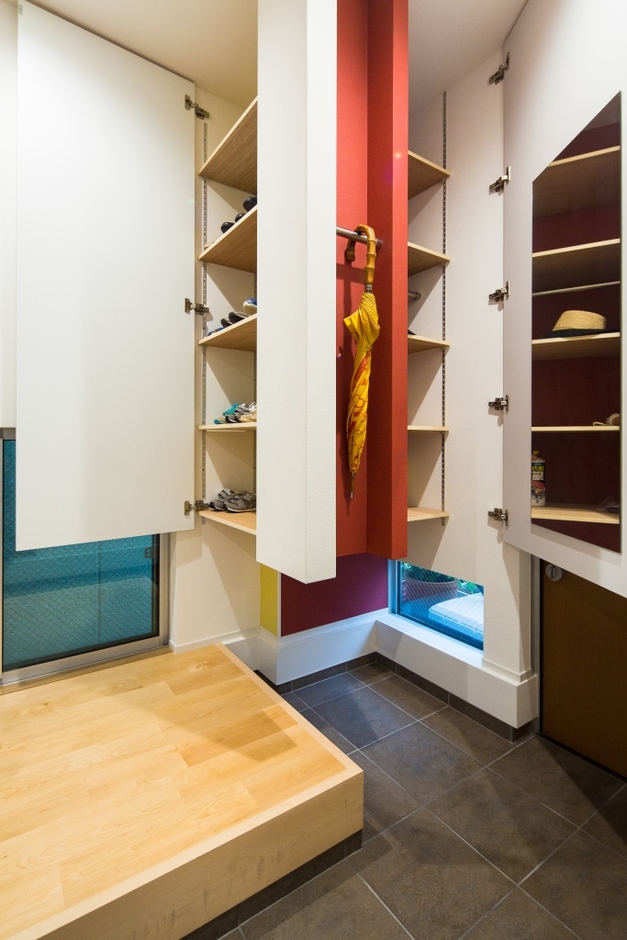 玄関横のシュークローゼットと傘などの収納スペースは壁紙で遊び心を演出し、鏡も設置して狭い空間を有効に活用