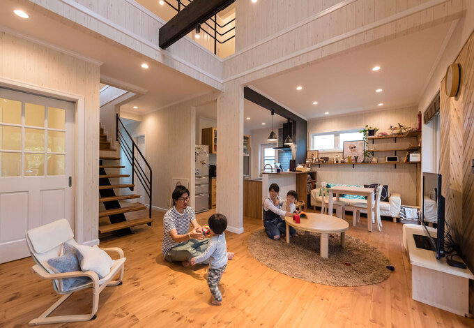 パインの床材を用いた吹抜けのあるリビング。黒いアイアンのスケルトン階段や、Yさんが集めたインテリアもオシャレ