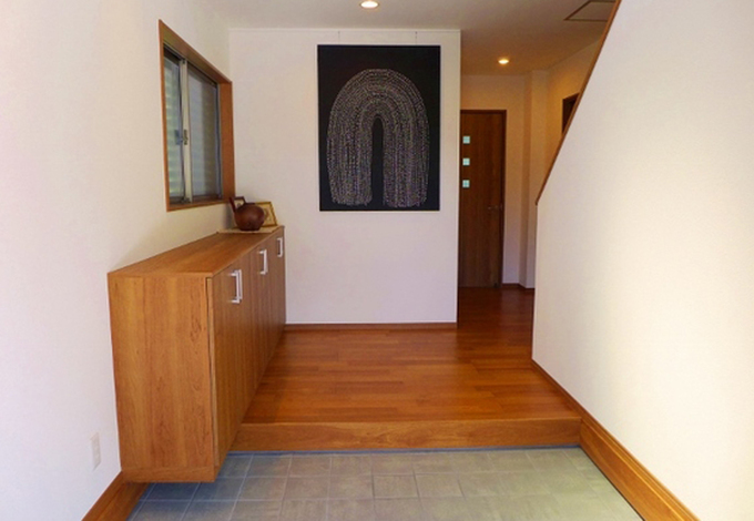 幅がゆったり広めの玄関スペース。高さを落としたカウンタータイプの靴箱を設置して圧迫感のない空間に