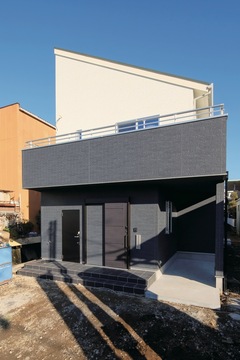 太陽光発電の効率に配慮し、片流れの屋根を採用した。玄関右にはサイクルヤードも備えられている【大成工務店】