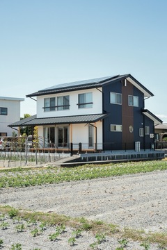 のどかな風景の中、安心感のある佇まいを見せる。通り側を閉じ、南を開く設計で、プライバシーを守りながら光と風が招かれる【福工房】