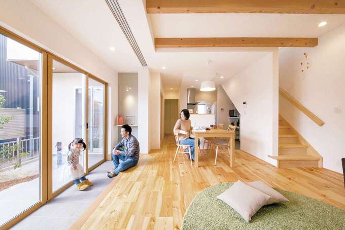 土間のあるLDK。無垢の床と白の空間に天井の梁がアクセント。土間を挟んだ庭の借景は、一幅の絵画のよう