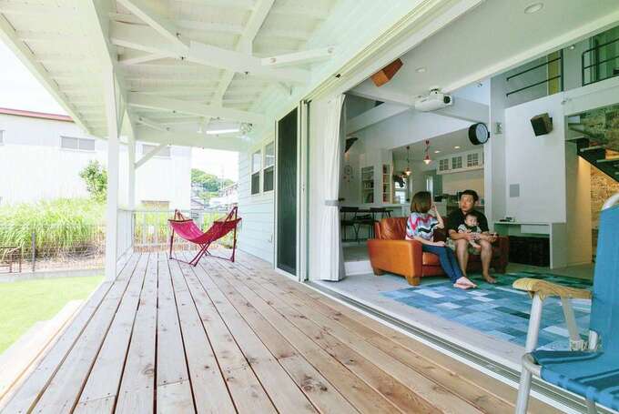 建物の幅いっぱいに伸ばした屋根付きのポーチは、日差しを遮り風が通り抜ける極上のくつろぎスペース。リビングの窓は全開にでき、室内にいても開放感抜群だ