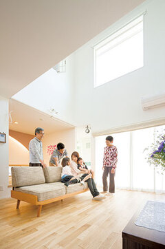 家族が交差する場所に配置されたリビング。シンプルな空間だが、吹き抜けから降り注ぐ光と無垢のナラの風合いがほっとする雰囲気をつくり出している。窓の外のウッドデッキが完成すれば、さらに気持ちよさがアップ