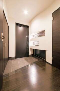 玄関の上り框には、キッチンカウンターと同じ天然の御影石を採用。アールを描いたニッチには、エコカラットを貼り、訪れる人を迎える空間を爽やかに保つ