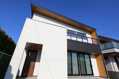 モダンなデザインの二階建て住宅の外観。大きな窓が特徴であり、自然光をたくさん取り入れることができる。深い軒で雨の日も安心。【片桐建設】