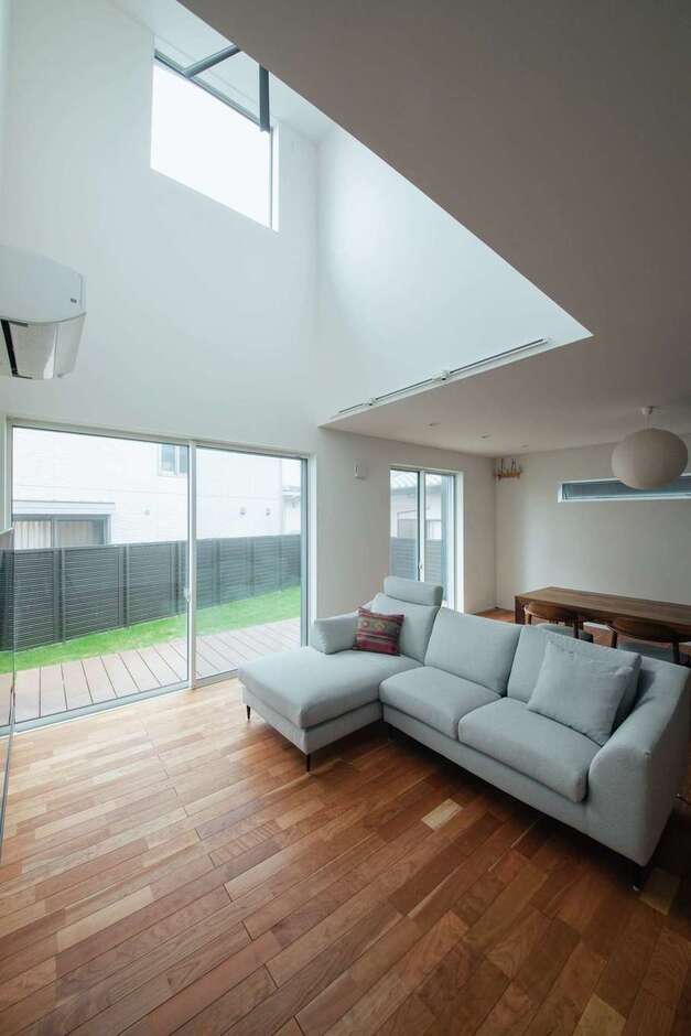 南面に隣家が建っており、採光に不安があったことから、リビングに大開口と4.5畳分の吹き抜けを採用し、たっぷりの光を招き入れるように工夫した。フローリングは無垢のブラックチェリーで、経年変化が楽しみ