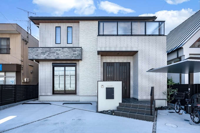 落ち着いた色調と直線的なフォルムが調和した、モダンな二階建て住宅。シンプルながらも洗練された印象を与える外観デザイン。