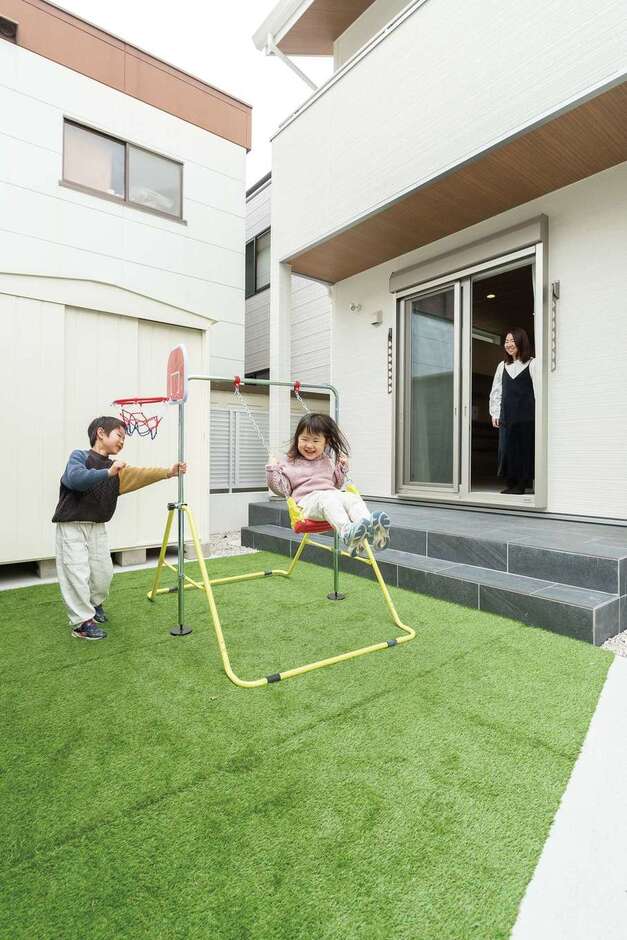 人工芝を敷いた庭で、ブランコやバスケを楽しむ