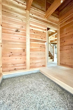 自然素材を使用した玄関。木の温もりが感じられる落ち着いた空間で、外部と内部の緩やかなつながりを演出。【明城】
