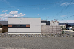シンプルでモダンな外観デザインが特徴の住宅。直線的なフォルムとシックなカラーリングが街並みの中で一際目立つ。【チェックハウス】