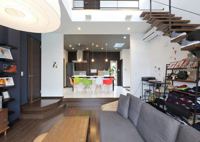 吹抜けが開放感を増し、2段上下させたことでフロアの見え方に変化が生まれる。キッチンまでの奥行やクロスの色合いなど、こだわりが凝縮された空間