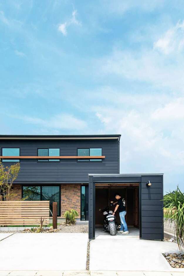 「木箱house」の前面にバイクガレージ用の「木箱mini」を設け、統一感のある外観が実現。黒い外壁のアクセントにレンガ調の外壁を組み合わせたのがご主人のこだわり