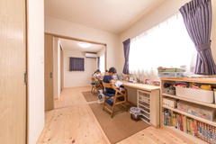 収納以外の建具はより開放的にする為に、全て引き戸を採用。２つの子ども部屋の間仕切りも引き戸にして、生活スタイルに合わせて開け閉めできるようにしました。子ども部屋の勉強机や本棚は造作で揃えてスッキリまとめています。