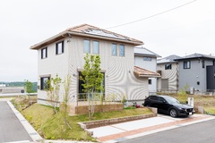 モダンなデザインの2階建て住宅の外観。庭には植樹され、自然と調和したエントランスが印象的。駐車スペースには車が停められている。【パナソニックホームズ中部第一支社 愛知第一支店・愛知第二支店】