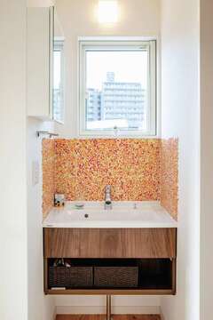 2階のトイレの横に設けた洗面台はタイル張りの壁が華やかさを添える