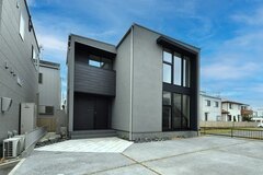 建物を段違いにずらす事により、敷地形状を活かした配置を実現。 玄関面には外壁にSORIDO（ソリド）を採用し、陰影が際立つ奥行のある外観がこだわりのポイントだ。