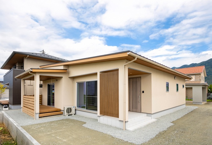 自然の風景に溶け込む、シンプルで温かみのある平屋の外観。木材を使ったアクセントが優しい印象を与えるデザイン。