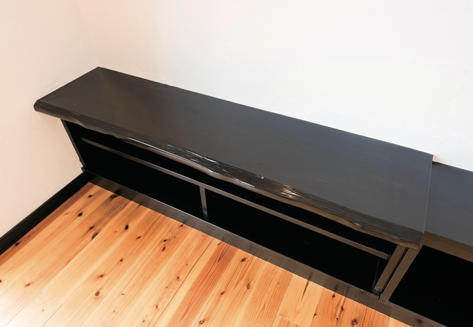 テレビボードは造作で。黒く塗装した一枚板が存在感を示す。白い塗り壁とのモノトーンもシックな印象