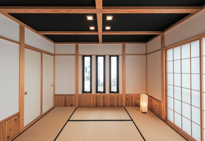 16.5畳のLDKと接する6畳の和室。黒い天井と照明が個性的