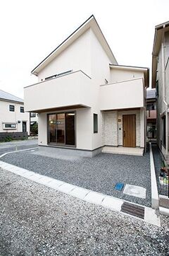 玄関まわりは木製扉や石組み風のタイル使いでナチュラルに