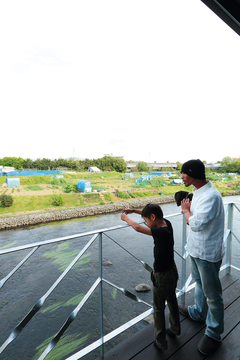 1階のテラスは川により近く、川からの風が 心地よくリビングに流れてくる【工藤建設】