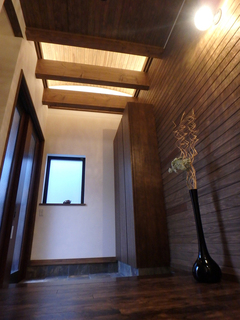 玄関天井には梁と間接照明が客人を優しく迎え入れてくれる