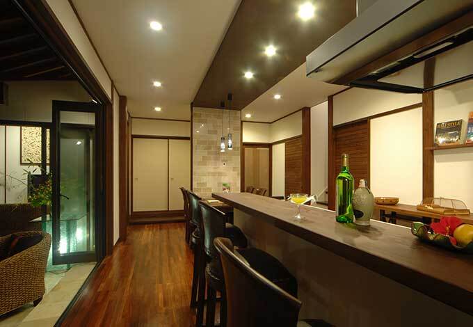 無垢の一枚板を惜しげもなく使用した、本格的なバーカウンターをテラス近くに設置。ガーデンパーティーなど、南国スタイルを満喫。チェアは現地で作らせたカネタケオリジナル品