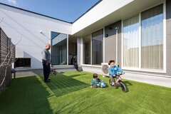 人工芝を敷いた中庭でのびのび遊ぶ子どもたち。フェンスを高めに設け、外部からの視線が気にならないように工夫されている【Custom House（カスタムハウス）】