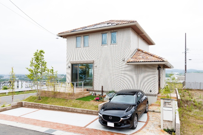 スタイリッシュな外観を持つ2階建て住宅。屋根と外壁には落ち着いた色合いが選ばれ、シンプルながらもエレガントな印象を与えている。
