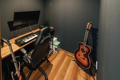 整然とした音楽ルーム。ギターやキーボードが配置され、音楽制作に最適な環境が整っている。【チェックハウス】