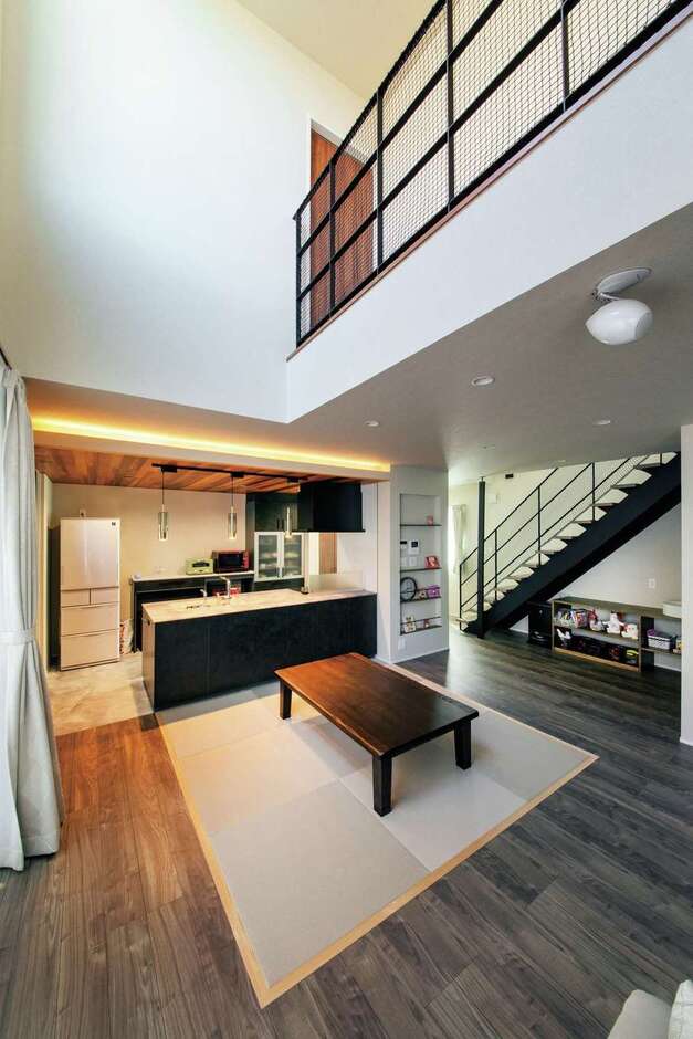 空中廊下のあるダイナミックな吹抜けのLDK。東の高窓からちょうどいい明るさの光が長時間射し込む。夫婦共通の希望だった畳ダイニングは、疲れたときにすぐゴロンと横になれて便利