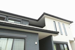 モダンなデザインの住宅外観。白と黒のコントラストが印象的で、シンプルながら洗練された雰囲気を漂わせている。