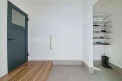 シューズクローク付きの玄関はネイビーブルーのリビングドアがアクセント