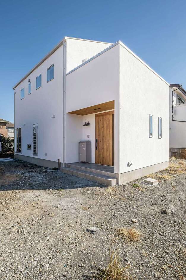 喰の白にドアの木や照明が映える