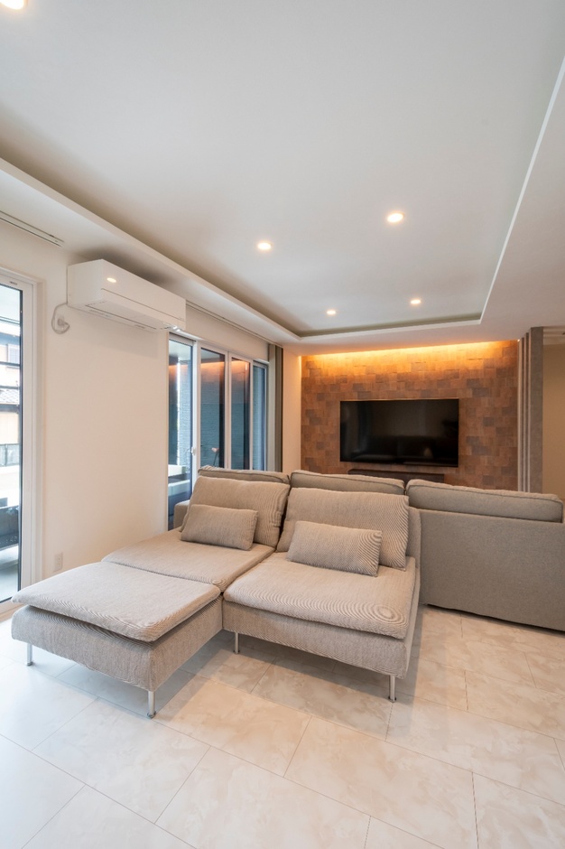 テレビが設置されたエンターテインメントスペースがあるリビング。快適なソファがあり、ゆったりと過ごせる空間を提供する。