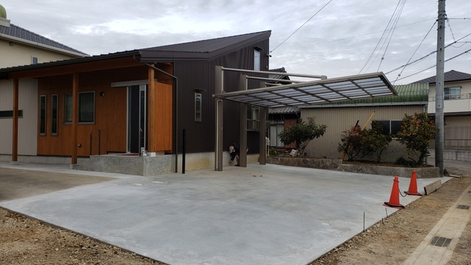 モダンなデザインの平屋建築。シンプルなカーポートが備えられており、広々とした駐車スペースが特徴的である。
