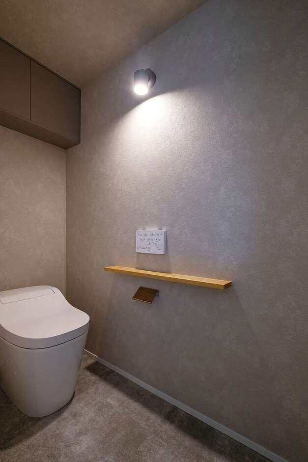 トイレはグレーの落ち着いた空間。壁を照らす照明がおしゃれ