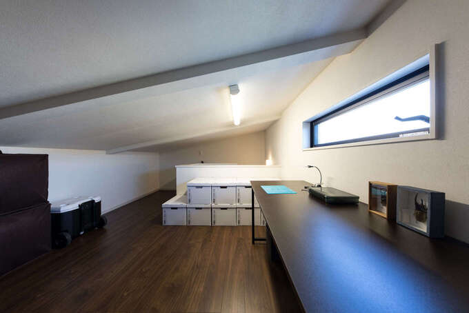 屋根の勾配部分を活用した小屋裏はご主人の趣味部屋に。スリット窓を取り付けて採光と換気対策も万全