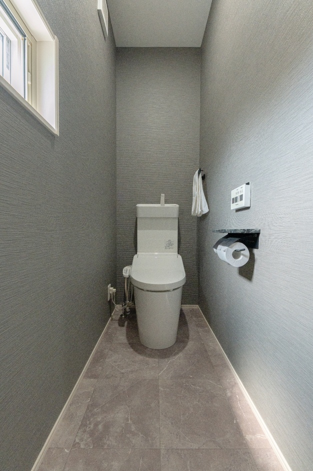 シンプルで落ち着いた色調のトイレ空間。
コンパクトながらも必要な設備を備えており、機能的で使いやすいデザイン。